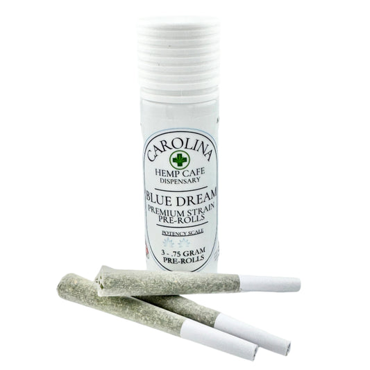 White cylinder Jar by Carolina Hemp Cafe with 3 pre-rolls laying in front of it.  Label says Blue Dream