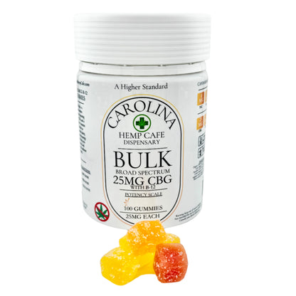 A bottle of Carolina Hemp Dispensary's Bulk 25mg CBG Gummies with a couple of gummy candies in the front. The gummies appear colorful with shapes like smiley faces and stars.