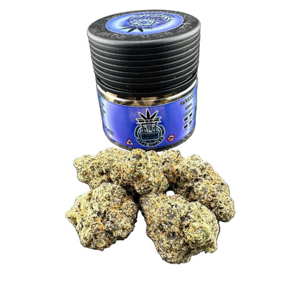 Jar of cannabis buds with a blue label on a dark surface