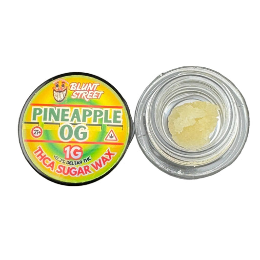 Container of Pineapple OG THCA sugar wax with a visible label on a gray background
