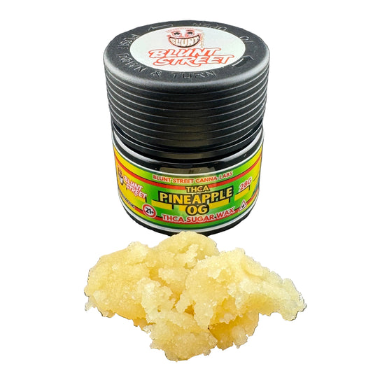 Jar of pineapple flavored wax with a black lid on a gray background
