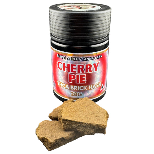 A jar of Blunt's Street Canna Labs Cherry Pie THGA Brick Hash (28g) shown with several pieces of the brown hash displayed in front on a white background.