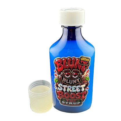A blue bottle of Blunt Street Boost THC Syrup with a white cap, shown next to a small clear plastic cup containing a pale yellow liquid, set against a dark gray background.