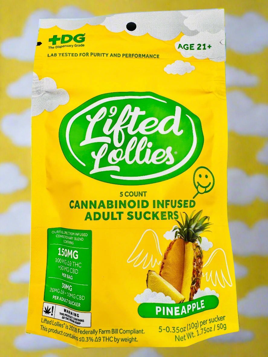 An assortment of Lifted Lollies THC lollipops with various colorful packaging displayed against a vibrant, cloud-filled sky background. Each lollipop has a different flavor label.