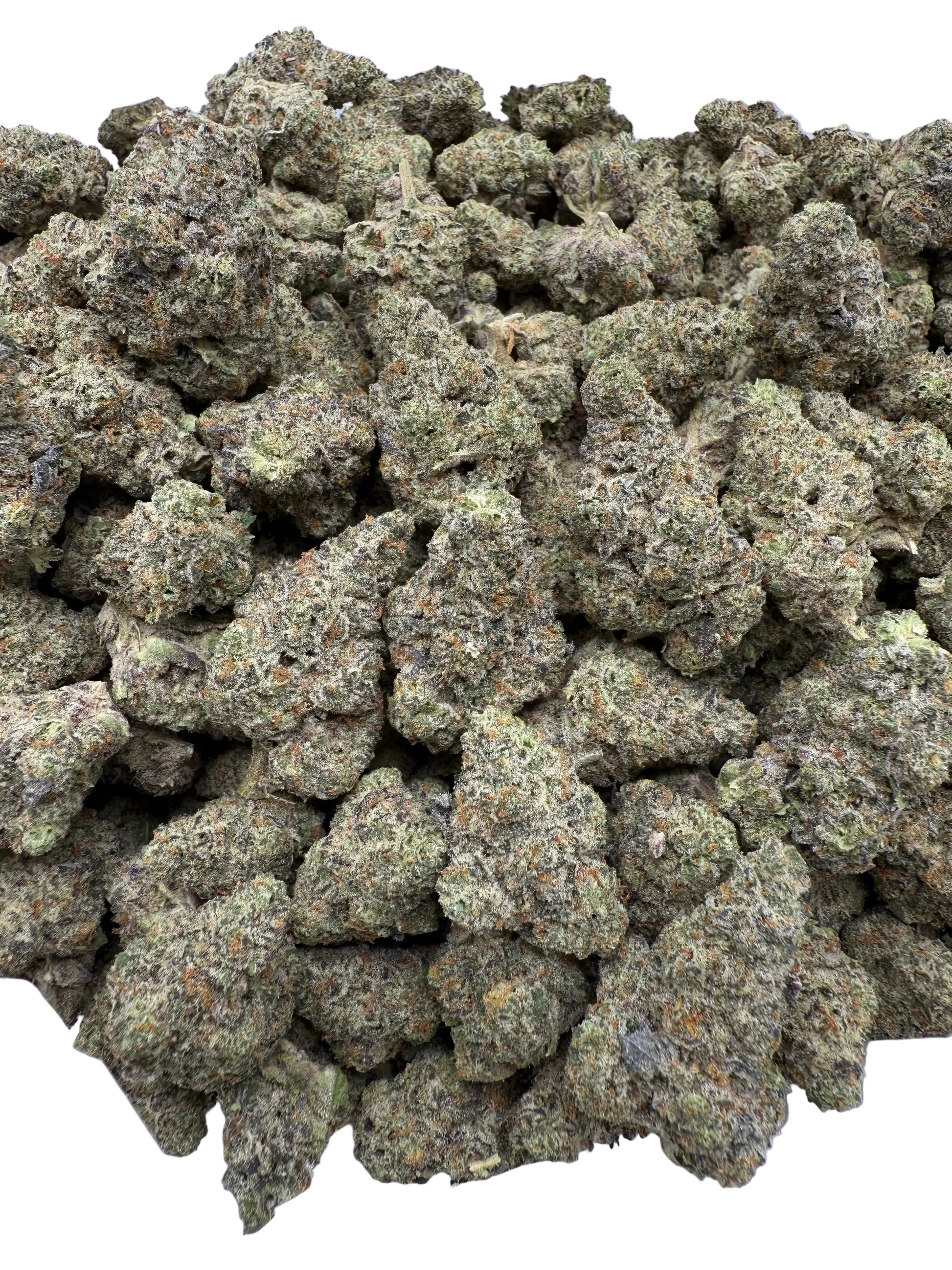 Close-up of a pile of green cannabis buds on a white surface
