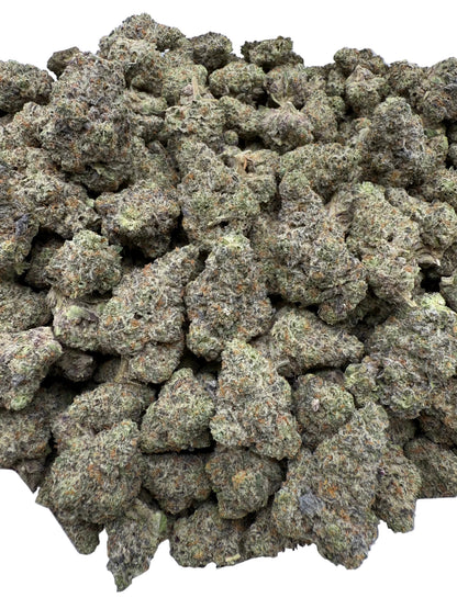 Close-up of a pile of green cannabis buds on a white surface