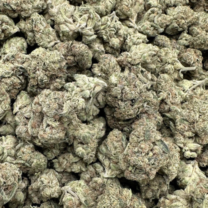 Close-up of a pile of green cannabis buds on a white background
