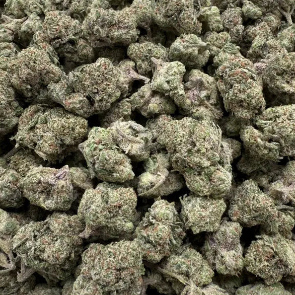 Close-up of green cannabis buds on a clear plastic background