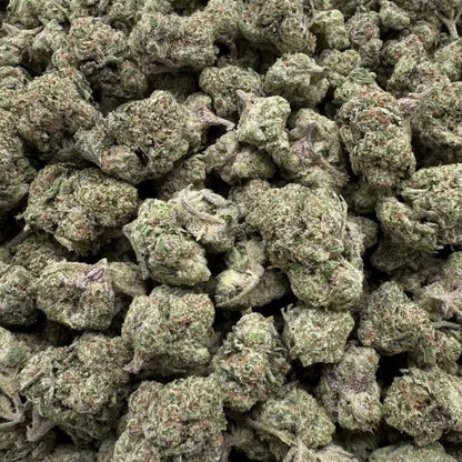 Close-up of green cannabis buds on a clear plastic background