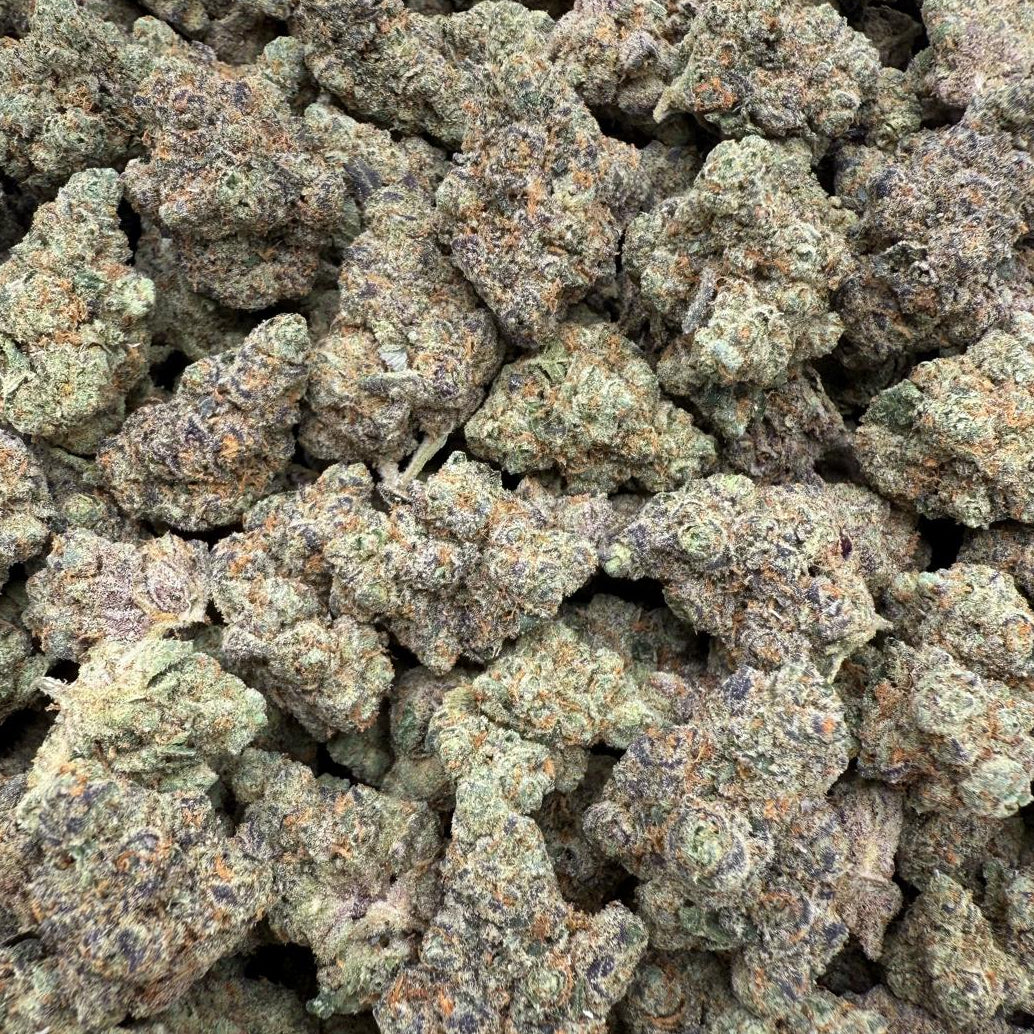 Close-up of a pile of green cannabis buds on a white background