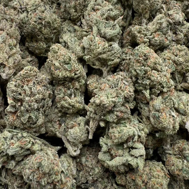 Close-up of a pile of green cannabis buds on a clear background